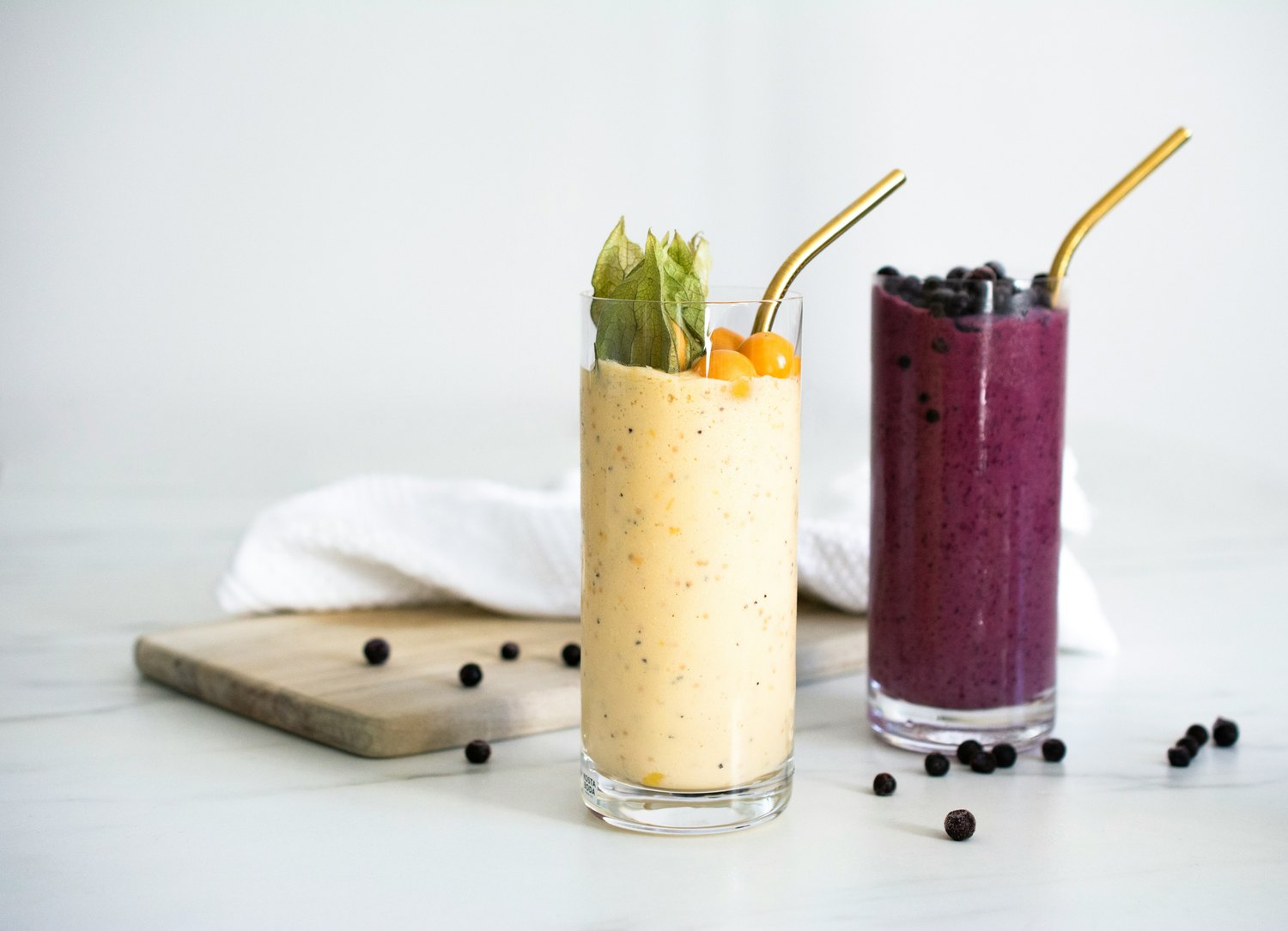 Golden and berry smoothies with fruit and reusable straws